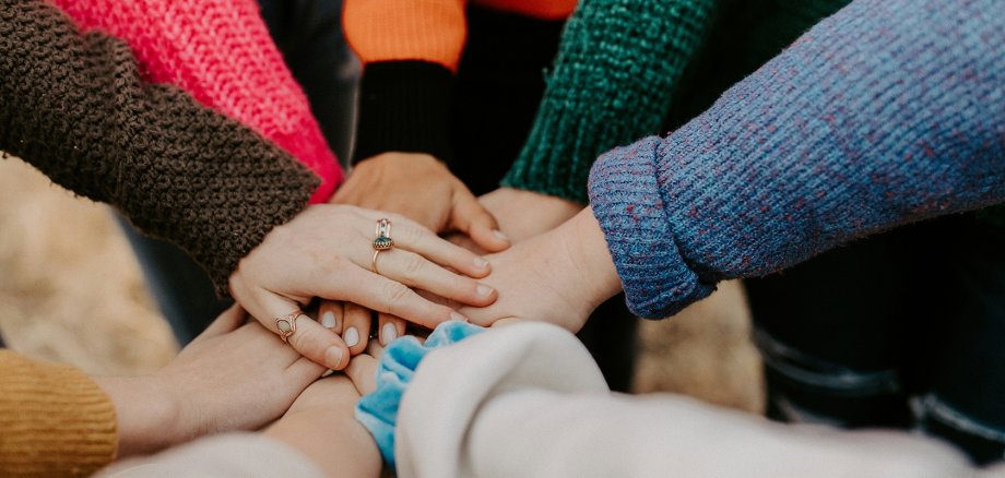 Integrations-Kommission Mehrere Hände, die sich in der Mitte berühren