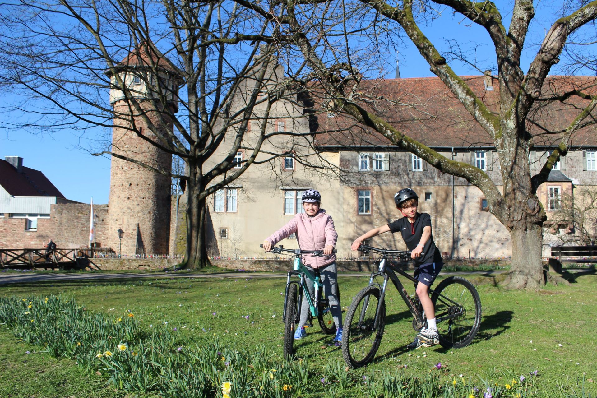Kinder mit Fahrrad auf einer Wiese