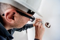 Elektriker verschraubt Steckdose in einer Wand