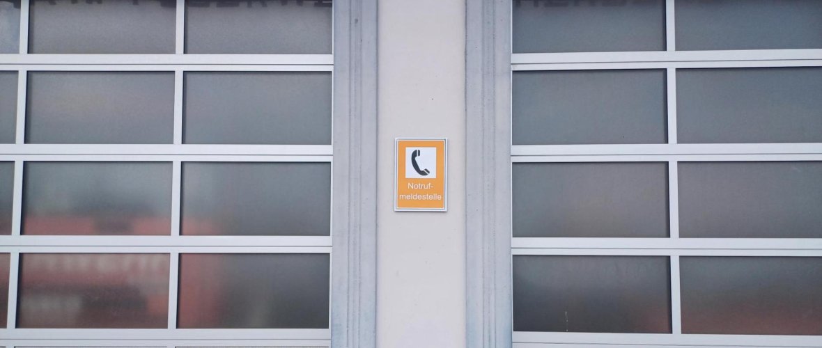 Feuerwehrtor mit Hinweisschild Notrufmeldestelle