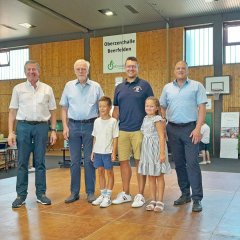 Verleihung Jugendförderpreis Erwachsene und zwei Kinder stehen zusammen auf Bühne