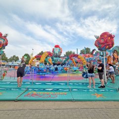 Blick auf buntes Fahrgeschäft mit einigen Gästen