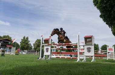 Springreiter beim Springturnier Springreiter über dem Hindernis